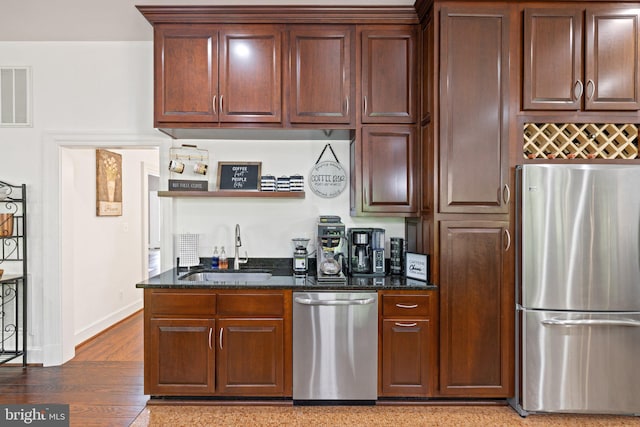 94 Tomahawk Way, Linden, VA 22642 - kitchen with stainless steel appliances, a sink, dark stone countertops, light wood finished floors, and baseboards