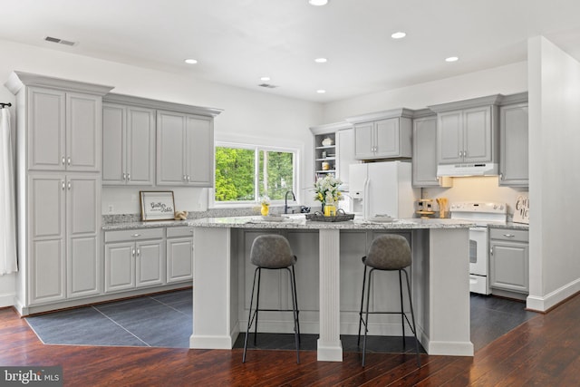 94 Tomahawk Way, Linden, VA 22642 - kitchen with white appliances, under cabinet range hood, gray cabinetry, dark wood finished floors, and a kitchen breakfast bar