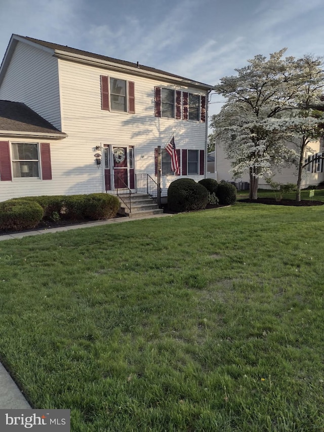 colonial inspired home featuring a front lawn