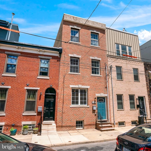 townhome / multi-family property featuring entry steps and brick siding