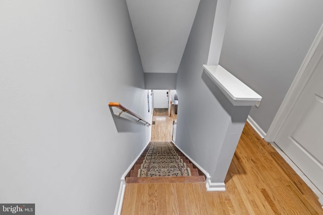 staircase with wood finished floors and baseboards
