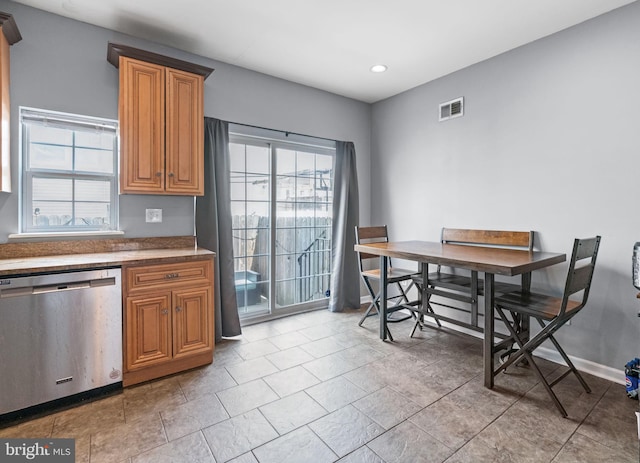 kitchen with stainless steel dishwasher, brown cabinetry, recessed lighting, baseboards, and dark countertops