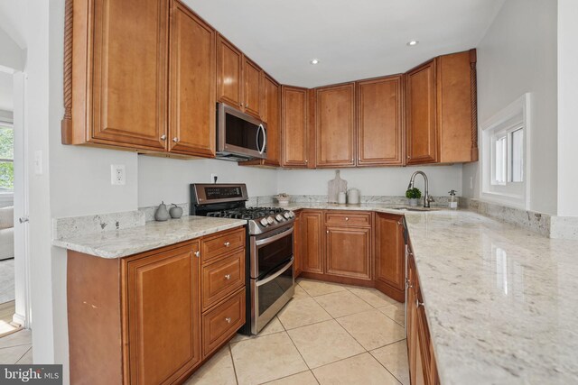 6924 Jefferson Ave, Falls Church, VA 22042 - kitchen with appliances with stainless steel finishes, a sink, light tile patterned floors, light stone countertops, and brown cabinetry