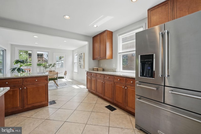6924 Jefferson Ave, Falls Church, VA 22042 - kitchen with stainless steel fridge, brown cabinetry, light stone counters, light tile patterned flooring, and recessed lighting