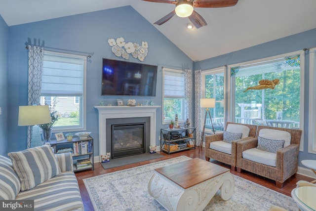20785 Rodney Dr, Rehoboth Beach, DE 19971 - living room with vaulted ceiling, wood finished floors, healthy amount of natural light, a ceiling fan, and a glass covered fireplace