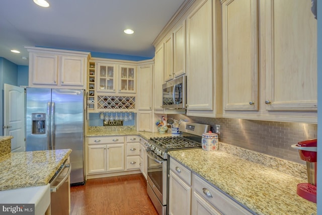 20785 Rodney Dr, Rehoboth Beach, DE 19971 - kitchen with appliances with stainless steel finishes, decorative backsplash, dark wood finished floors, light stone countertops, and recessed lighting