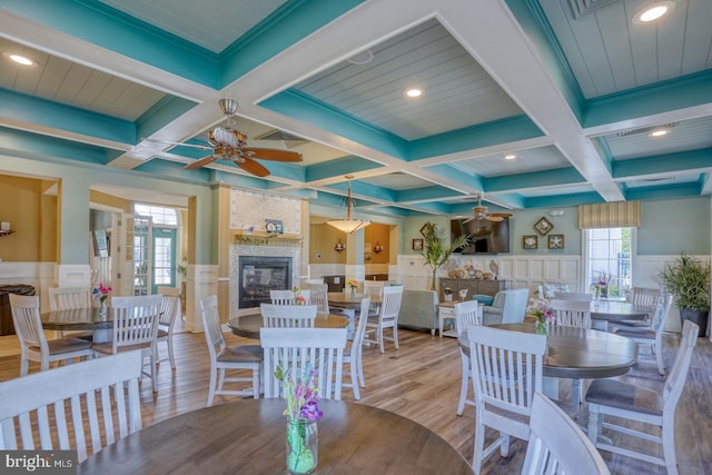 20785 Rodney Dr, Rehoboth Beach, DE 19971 - dining room featuring a ceiling fan, coffered ceiling, a large fireplace, wood finished floors, and beam ceiling