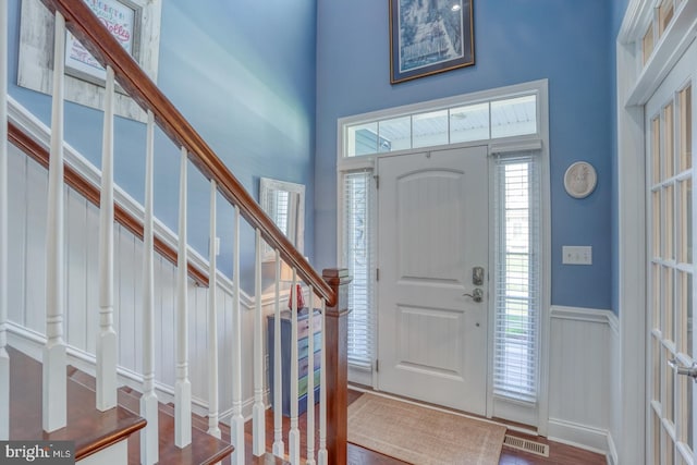 20785 Rodney Dr, Rehoboth Beach, DE 19971 - foyer with a high ceiling, stairs, and a wainscoted wall