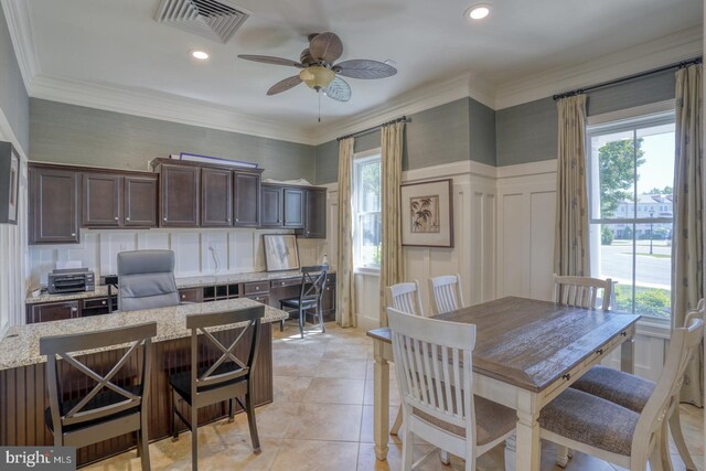 20785 Rodney Dr, Rehoboth Beach, DE 19971 - kitchen with healthy amount of natural light, ceiling fan, dark brown cabinets, light stone counters, and a decorative wall