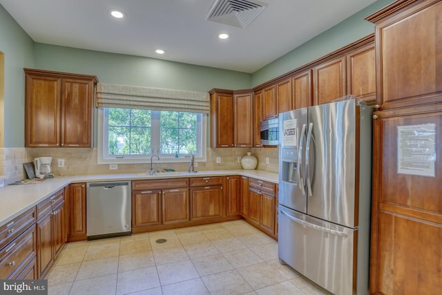 20785 Rodney Dr, Rehoboth Beach, DE 19971 - kitchen with appliances with stainless steel finishes, a sink, brown cabinetry, decorative backsplash, and recessed lighting