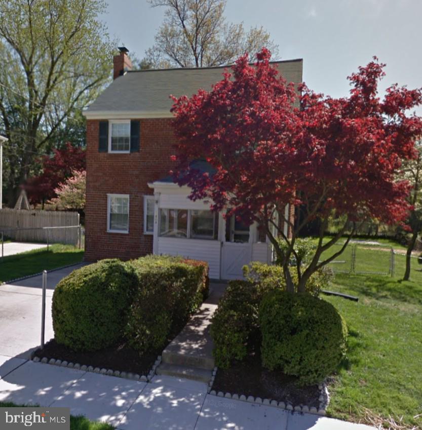 view of front of house with brick siding and a chimney