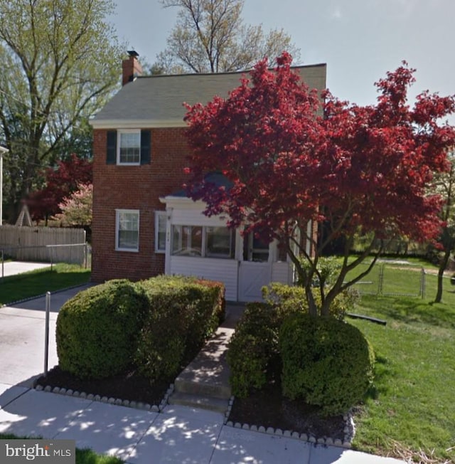 view of front of house with brick siding and a chimney