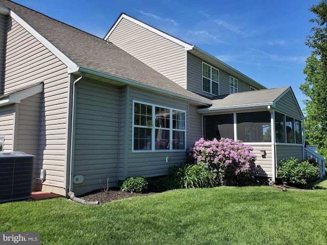 225 Canonero Dr, Bear, DE 19701 - view of property exterior featuring central AC unit, a sunroom, a lawn, and roof with shingles