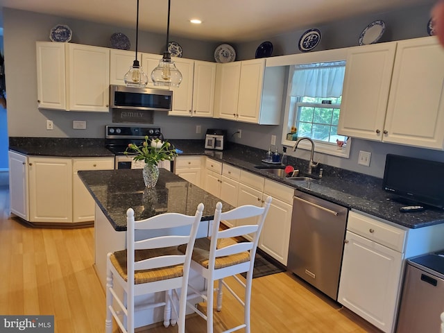 225 Canonero Dr, Bear, DE 19701 - kitchen with stainless steel appliances, a sink, white cabinets, light wood finished floors, and recessed lighting