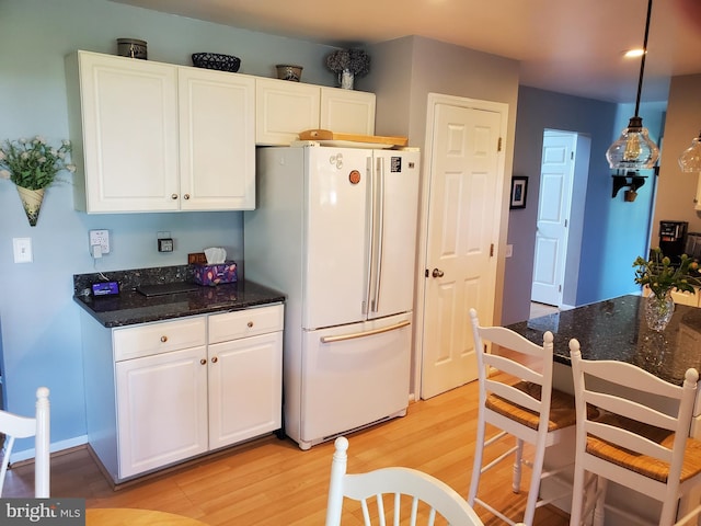 225 Canonero Dr, Bear, DE 19701 - kitchen featuring freestanding refrigerator, light wood finished floors, white cabinetry, dark stone countertops, and recessed lighting