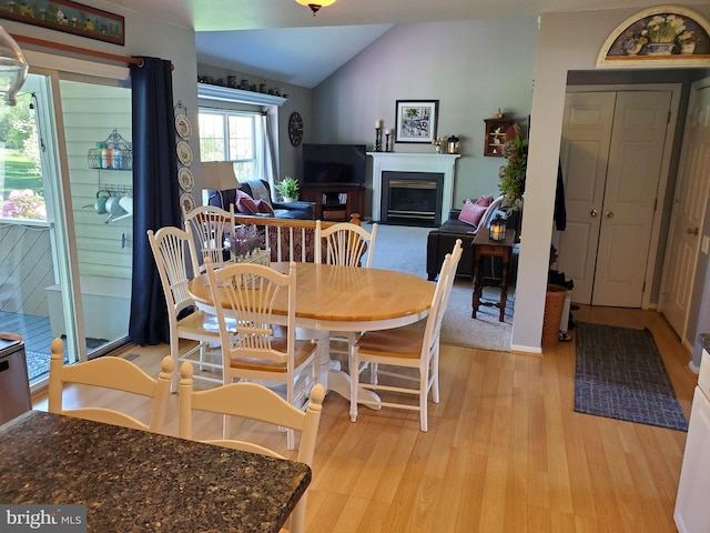 225 Canonero Dr, Bear, DE 19701 - dining space with lofted ceiling, light wood-style flooring, and a fireplace