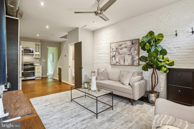 223 Parker St NE, Washington, DC 20002 - living area featuring wood finished floors, brick wall, a ceiling fan, recessed lighting, and baseboards