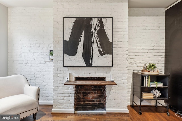 223 Parker St NE, Washington, DC 20002 - living area featuring wood finished floors, baseboards, and brick wall