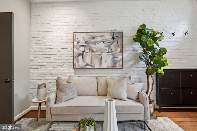 223 Parker St NE, Washington, DC 20002 - living area featuring brick wall, wood finished floors, and baseboards