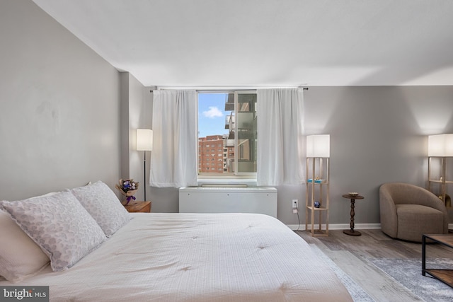 bedroom with wood finished floors and baseboards