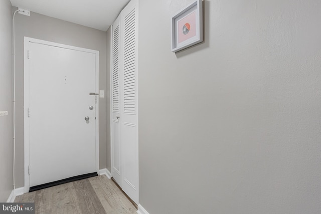 doorway to outside featuring light wood-type flooring and baseboards