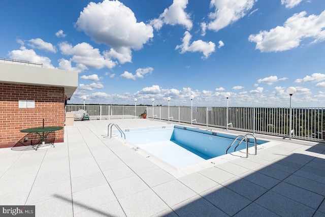 community pool with fence and a patio area