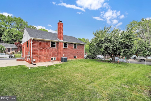 2129 Saranac St, Hyattsville, MD 20783 - back of property featuring brick siding, a chimney, central air condition unit, a patio, and a shingled roof