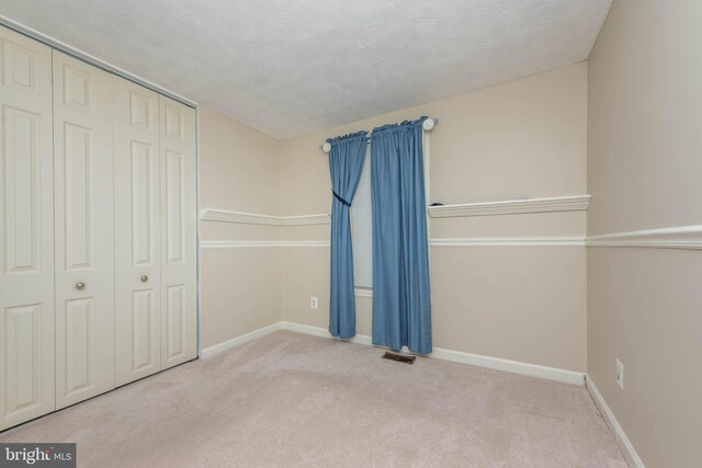 7037 Macbeth Way, Sykesville, MD 21784 - unfurnished bedroom with carpet floors, a closet, baseboards, and a textured ceiling
