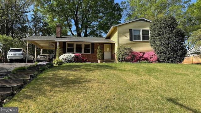 split level home featuring a chimney, a front lawn, a carport, and driveway