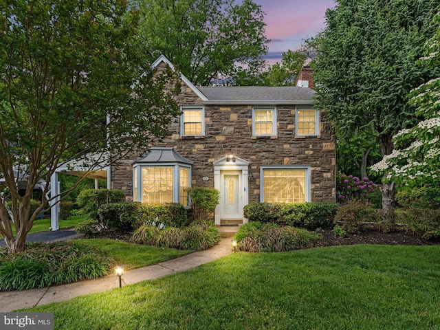 129 Kingston Rd, Cheltenham, PA 19012 - view of front of home with stone siding, a chimney, a lawn, and a shingled roof