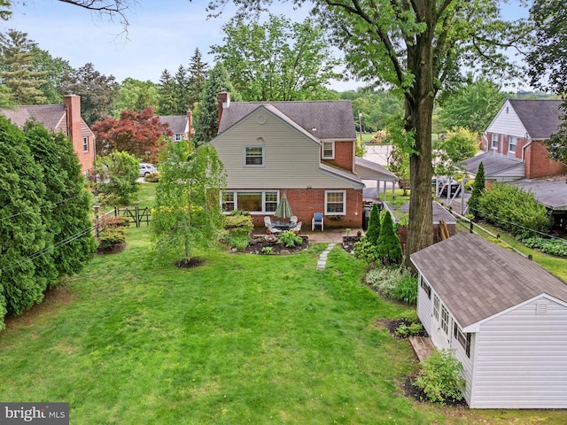 129 Kingston Rd, Cheltenham, PA 19012 - rear view of house with brick siding, an outdoor structure, a chimney, and a patio