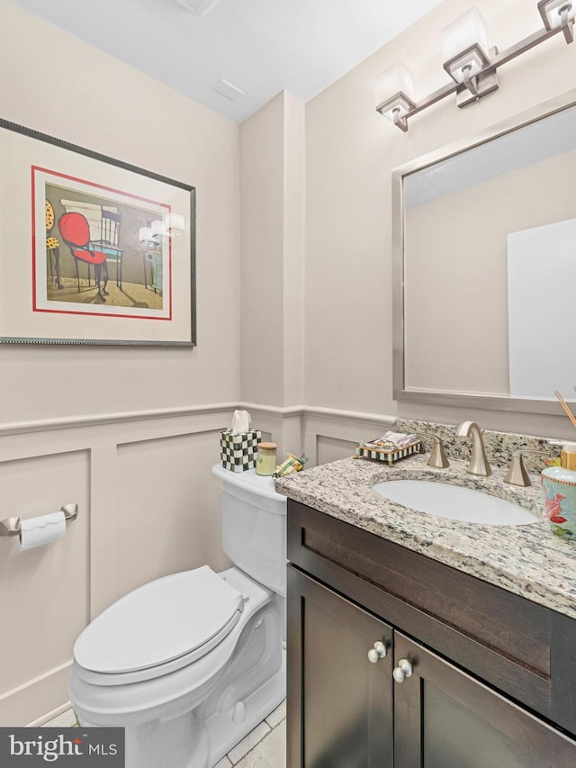 129 Kingston Rd, Cheltenham, PA 19012 - bathroom with toilet, vanity, a wainscoted wall, a decorative wall, and tile patterned floors