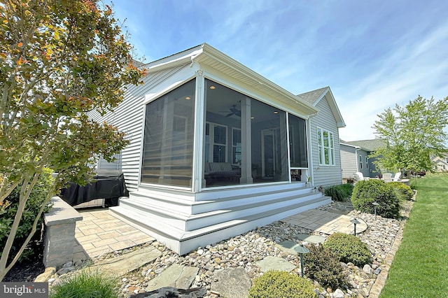 31840 Carmine Dr, Rehoboth Beach, DE 19971 - view of side of property with a sunroom, a ceiling fan, and a patio area