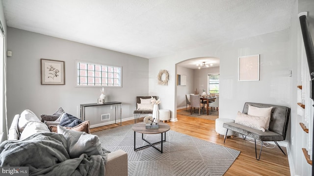 7913 Charlesmont Rd, Baltimore, MD 21222 - living room featuring arched walkways, wood finished floors, and baseboards