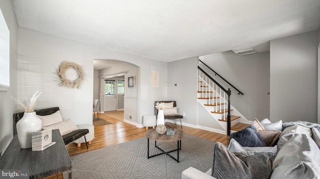 7913 Charlesmont Rd, Baltimore, MD 21222 - living area with arched walkways, wood finished floors, stairway, and baseboards