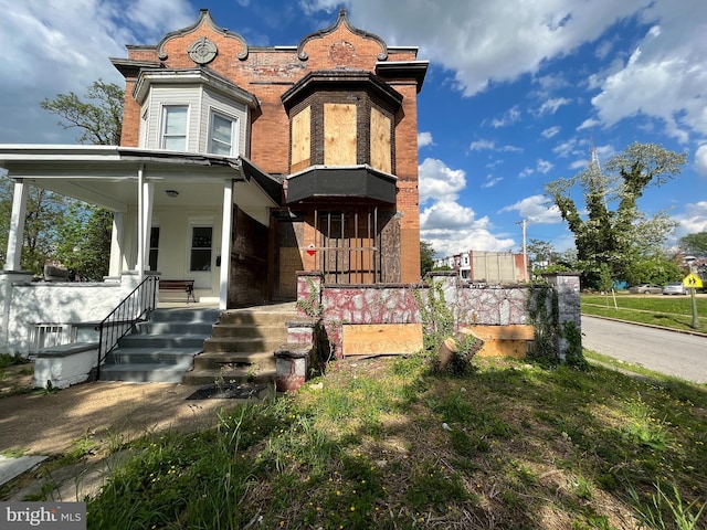 view of front of property featuring covered porch and brick siding