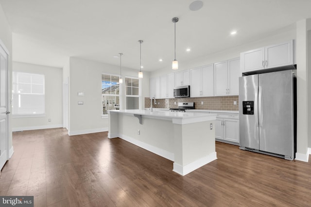 1552 Meadowlark Glen Rd, Dumfries, VA 22026 - kitchen featuring appliances with stainless steel finishes, light countertops, tasteful backsplash, an island with sink, and white cabinetry