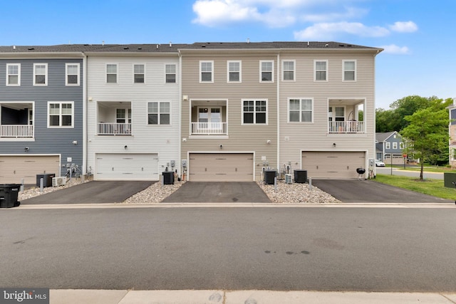 1552 Meadowlark Glen Rd, Dumfries, VA 22026 - rear view of house with an attached garage, central AC unit, and driveway