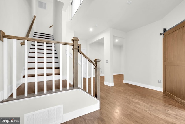 1552 Meadowlark Glen Rd, Dumfries, VA 22026 - staircase with a barn door, wood finished floors, recessed lighting, and baseboards