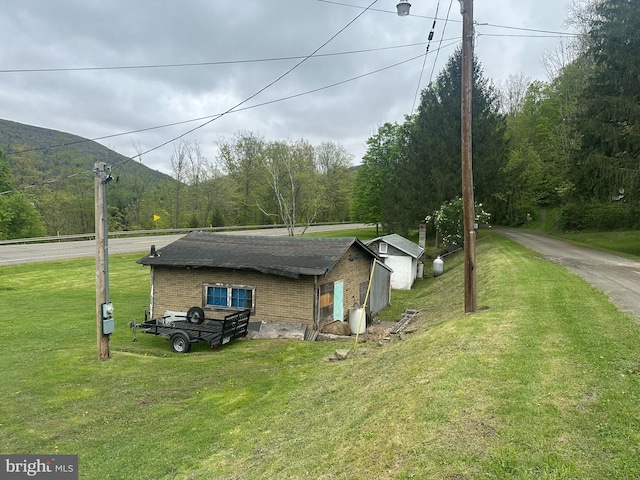 6528 Rte 6, Wellsboro, PA 16901 - view of side of home featuring a lawn, brick siding, and a wooded view