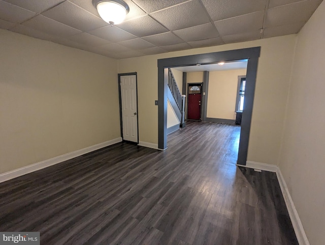 4133 Eierman Ave, Baltimore, MD 21206 - unfurnished room featuring a paneled ceiling, dark wood-style floors, baseboards, and stairway