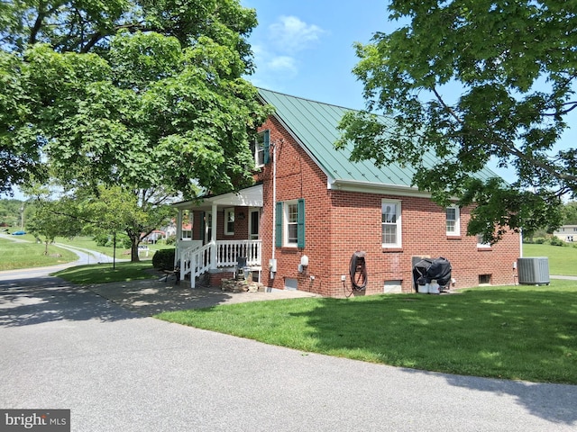 234 Bethel Grange Rd, Winchester, VA 22603 - view of property exterior featuring a standing seam roof, central air condition unit, brick siding, a lawn, and metal roof