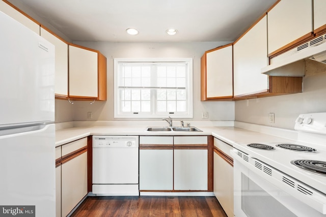 kitchen with white appliances, a sink, under cabinet range hood, light countertops, and recessed lighting