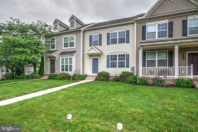 townhome / multi-family property featuring covered porch and a front lawn