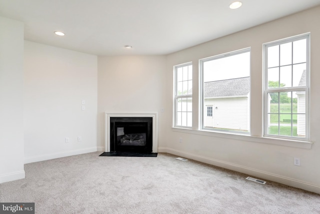 unfurnished living room with carpet floors, baseboards, recessed lighting, and a fireplace with flush hearth