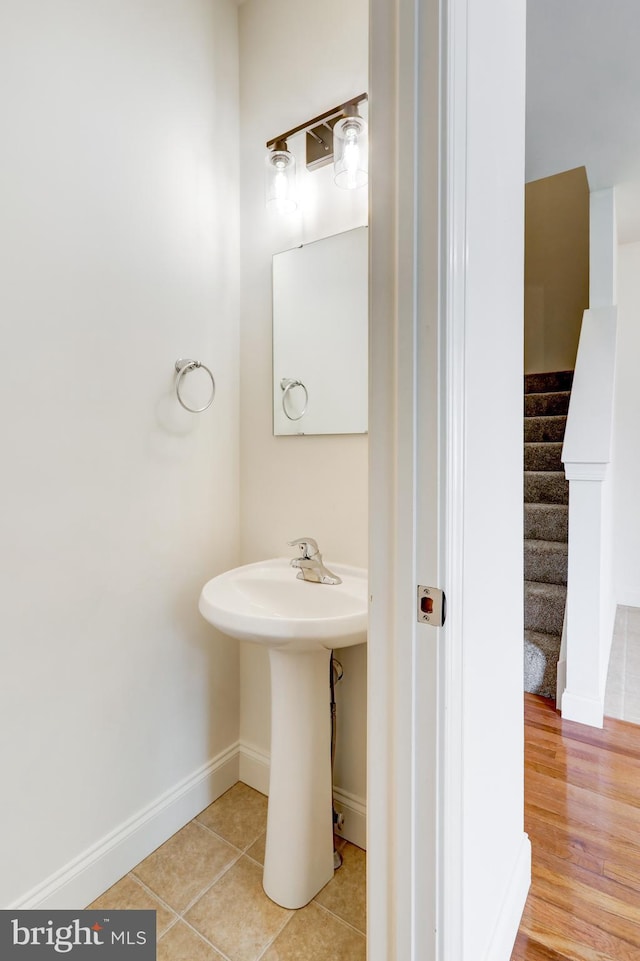 bathroom featuring baseboards, tile patterned flooring, and a sink