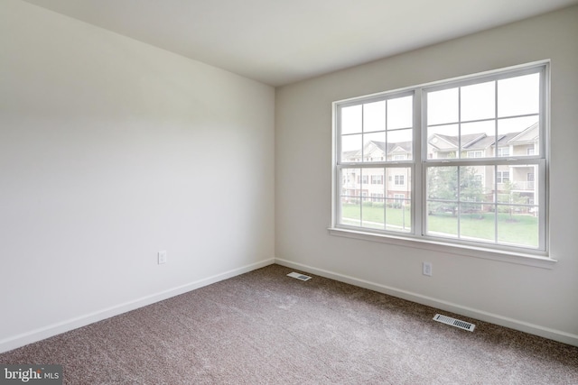 carpeted spare room featuring baseboards