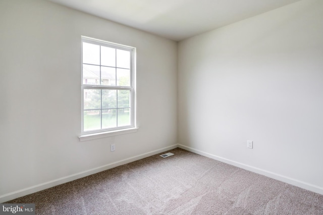 spare room with baseboards and carpet floors