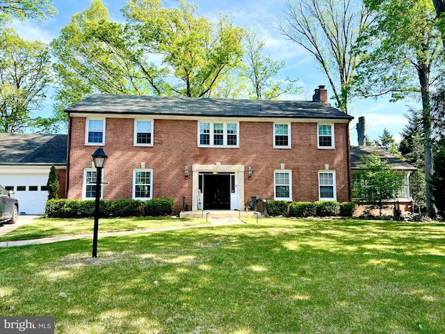 104 River Forest Ln, Fort Washington, MD 20744 - colonial home featuring a chimney, a front yard, a garage, and brick siding