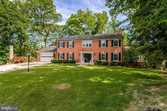 104 River Forest Ln, Fort Washington, MD 20744 - colonial-style house with a chimney, driveway, a front lawn, a garage, and brick siding